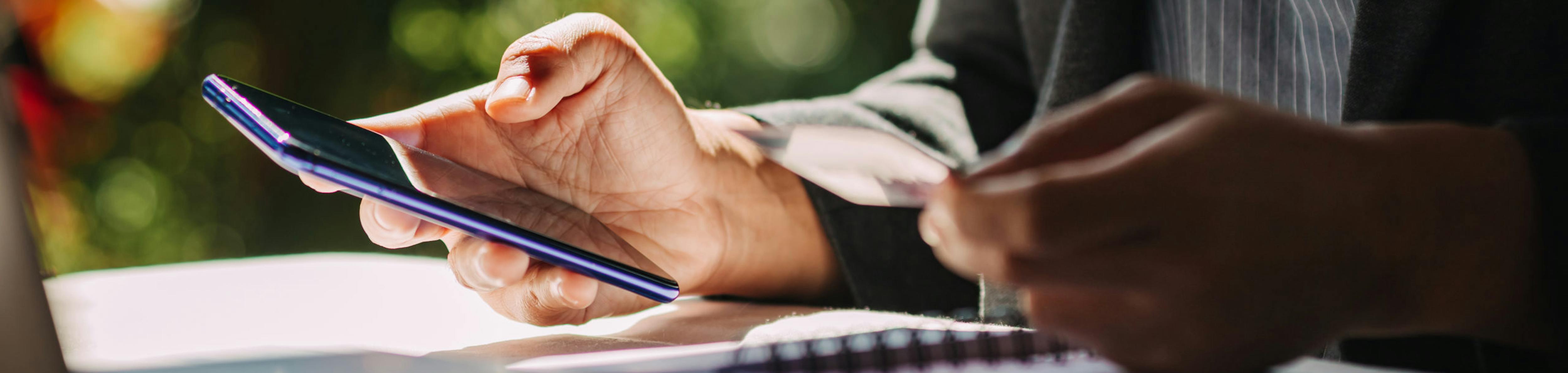 Hands holding credit card and using laptop for shopping online.